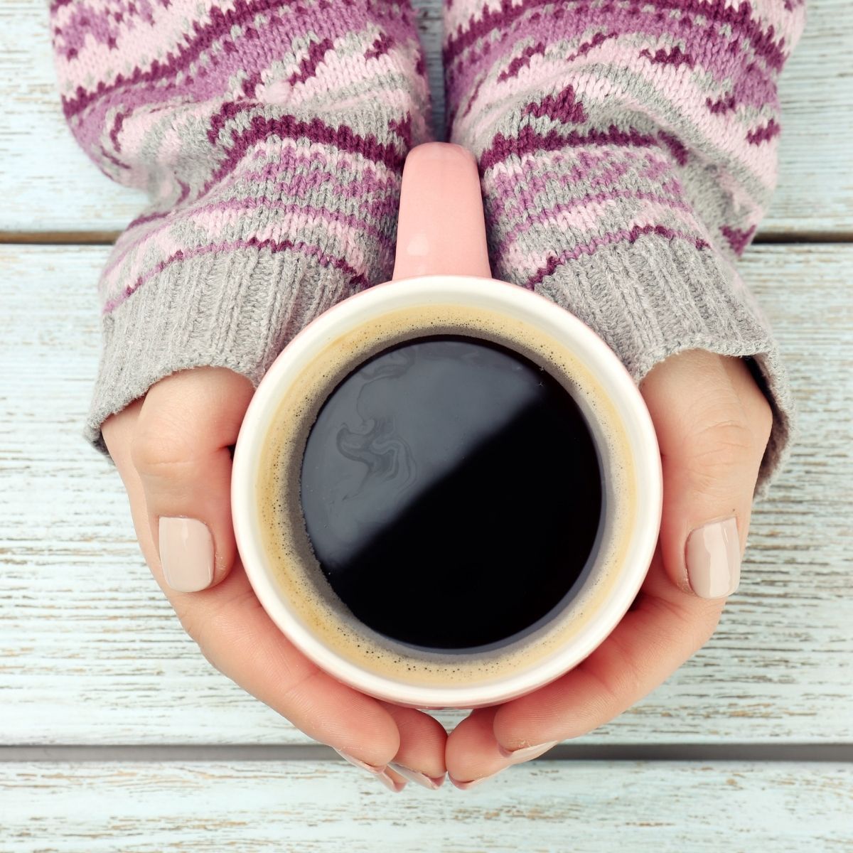 woman's hand holding coffee cup.