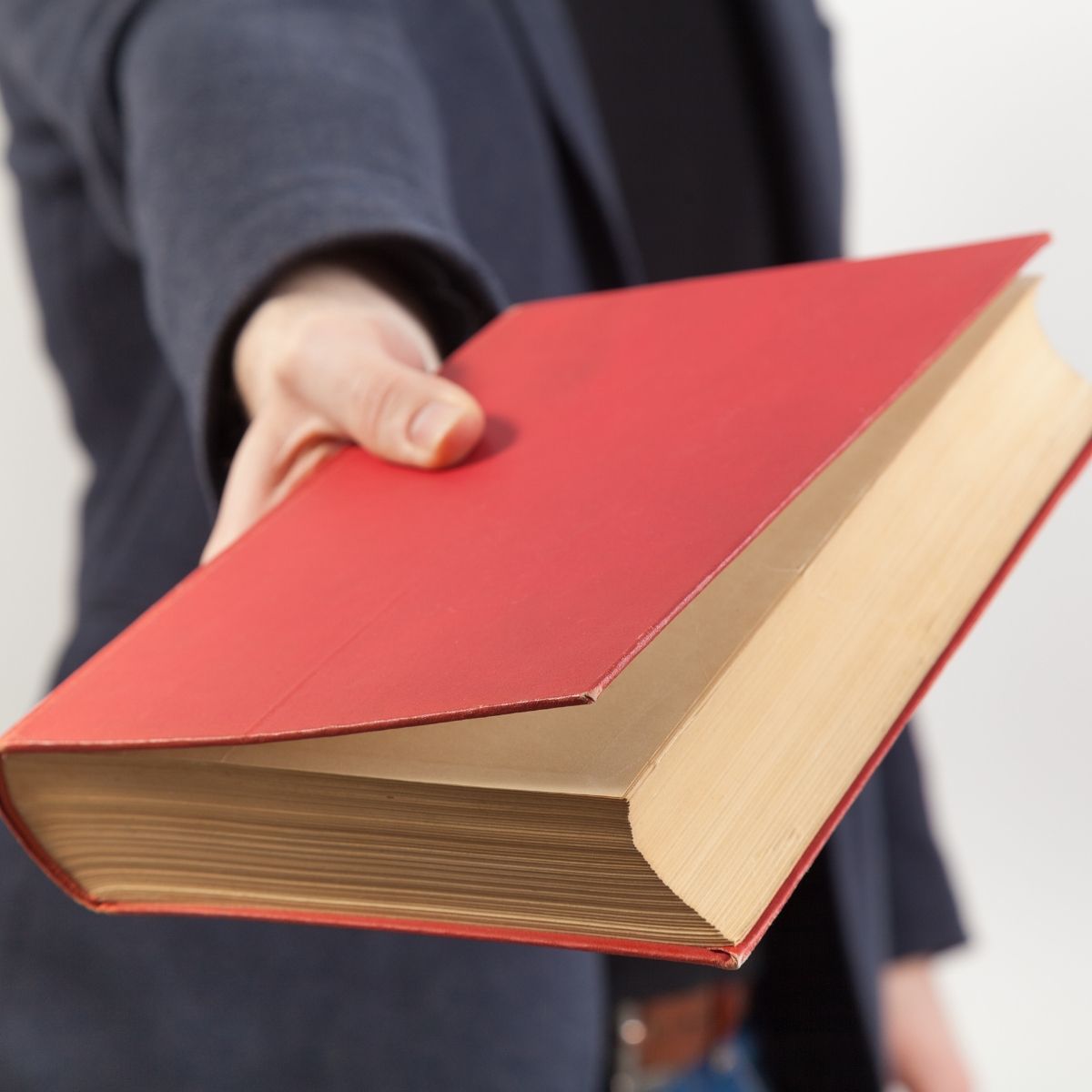 person handing a book over.