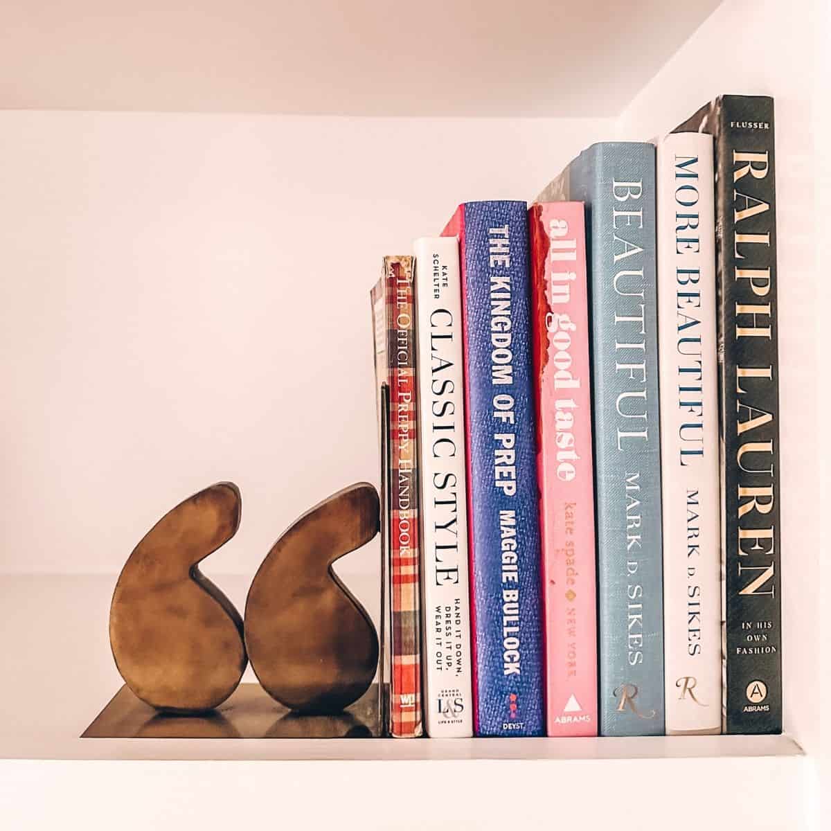 preppy books on bookshelf with bookend.