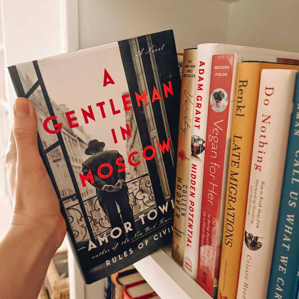 a gentleman in moscow by amor towles being pulled from a bookshelf.