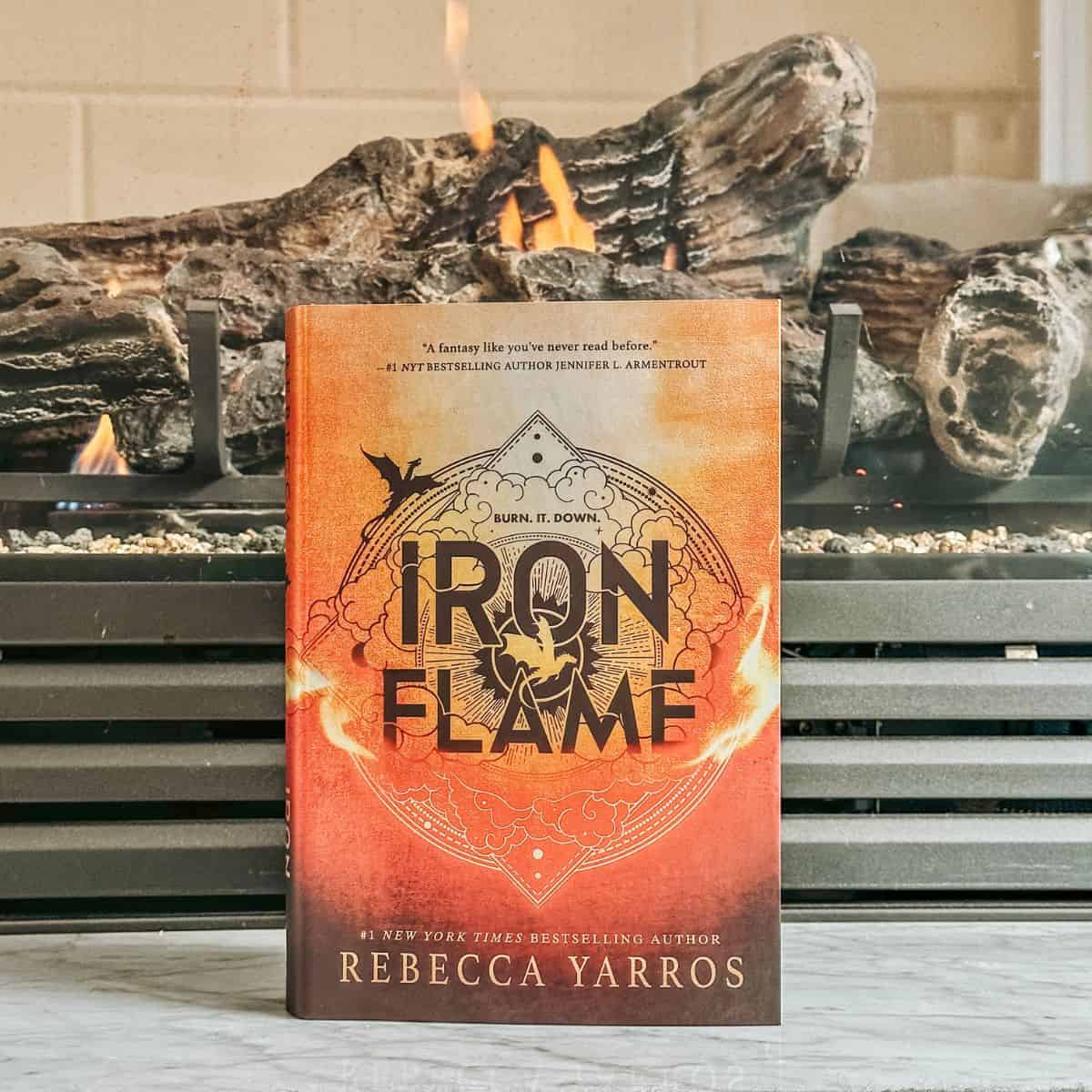 iron flame by rebecca yarros in front of a fireplace.