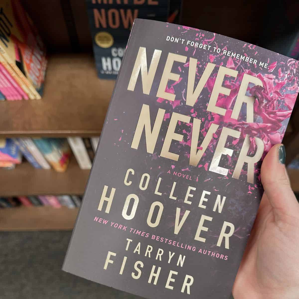 never never by colleen hoover in front of bookshelves.