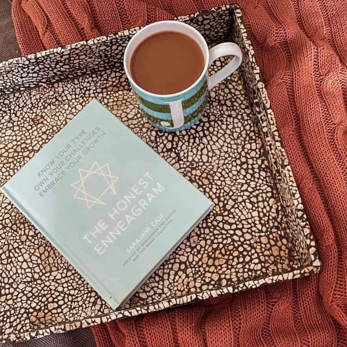 the honest enneagram book with coffee and a blanket.