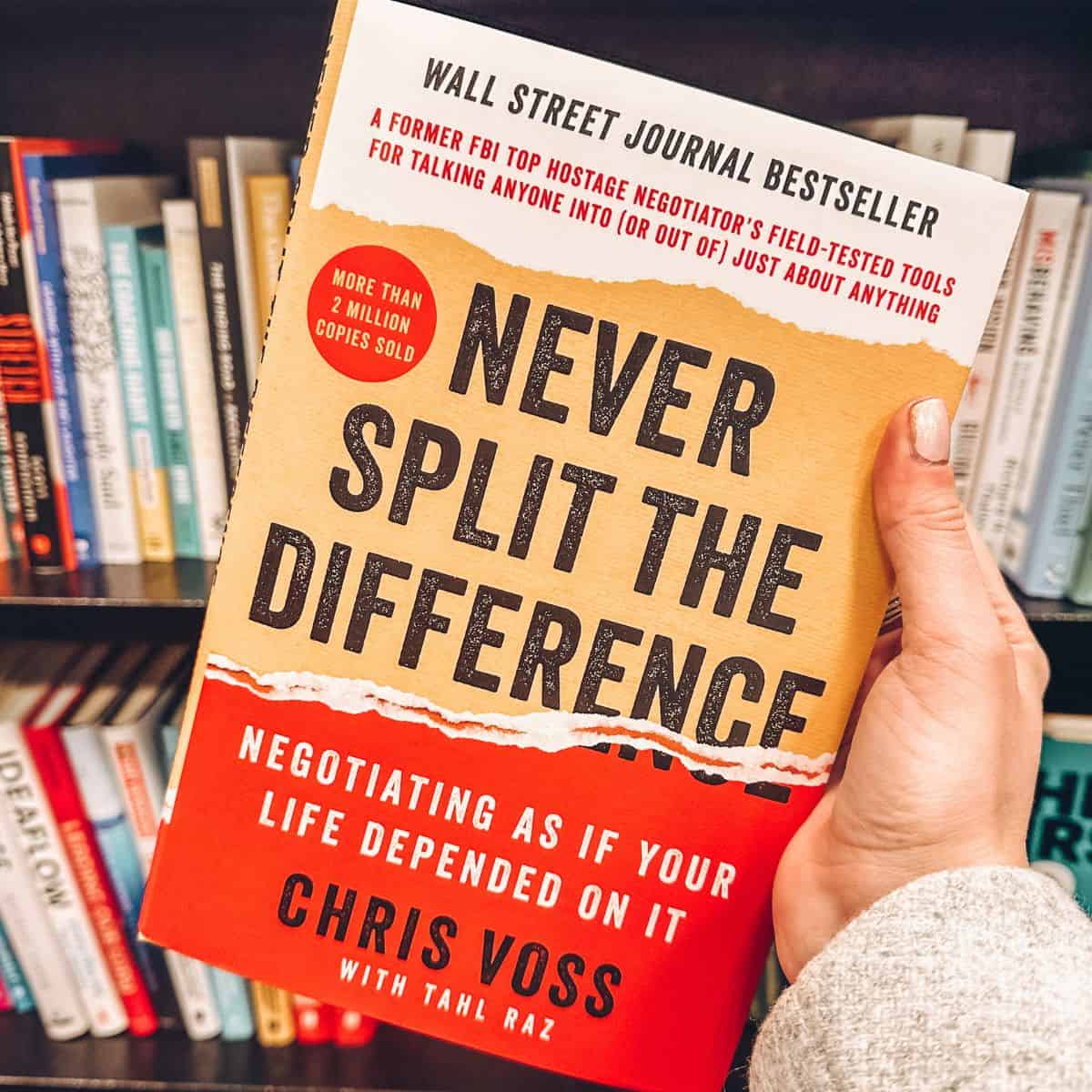 never split the difference by chris voss in front of a bookshelf.