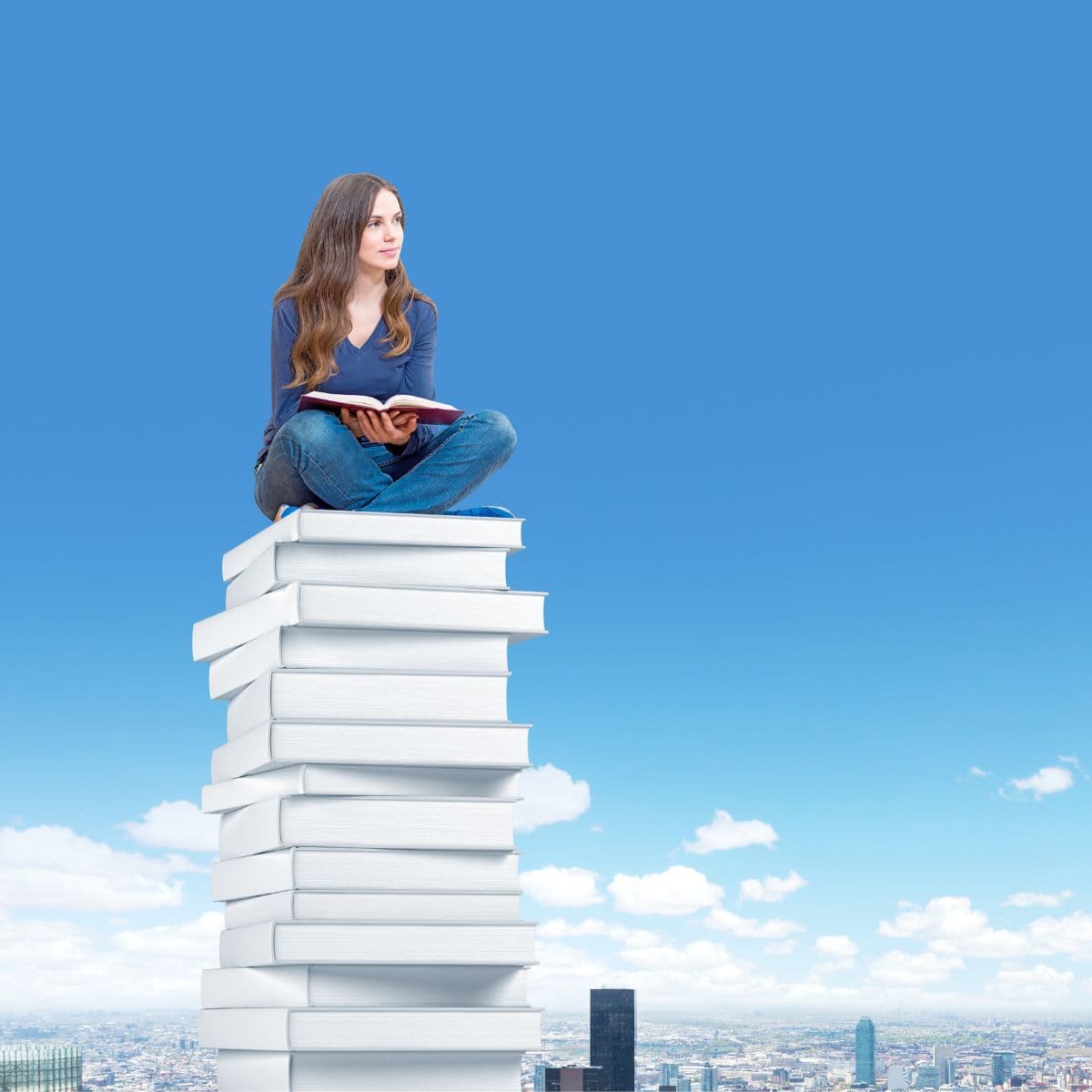 woman sitting on a stack of books.