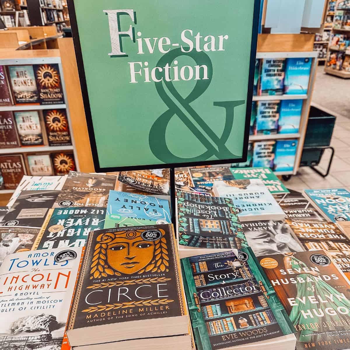 five star fiction sign with books on a table.