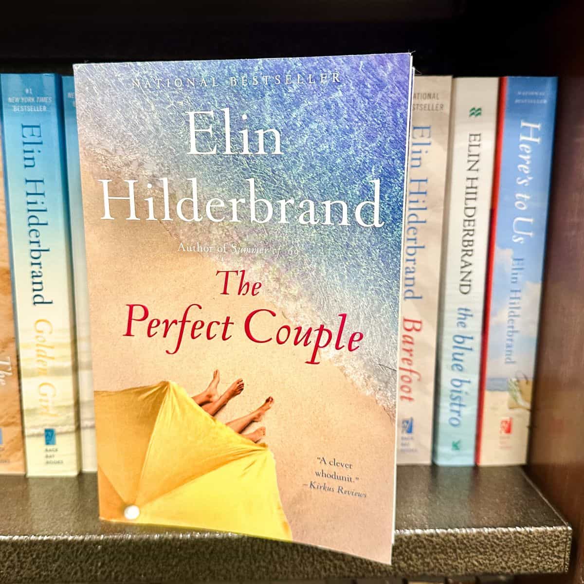 The perfect couple by Elin Hildebrand on a bookshelf with her other books.