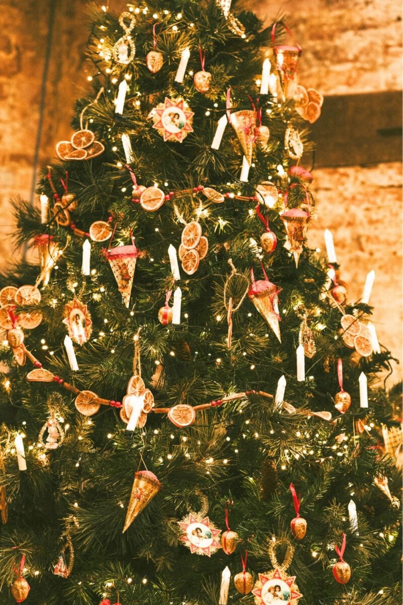 Old fashioned Christmas tree with dried fruit and candles.